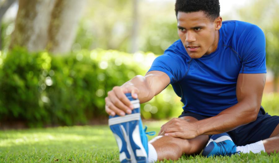 Atleet doet quadriceps stretch als preventie bij patellofemoraal pijnsyndroom oefeningen